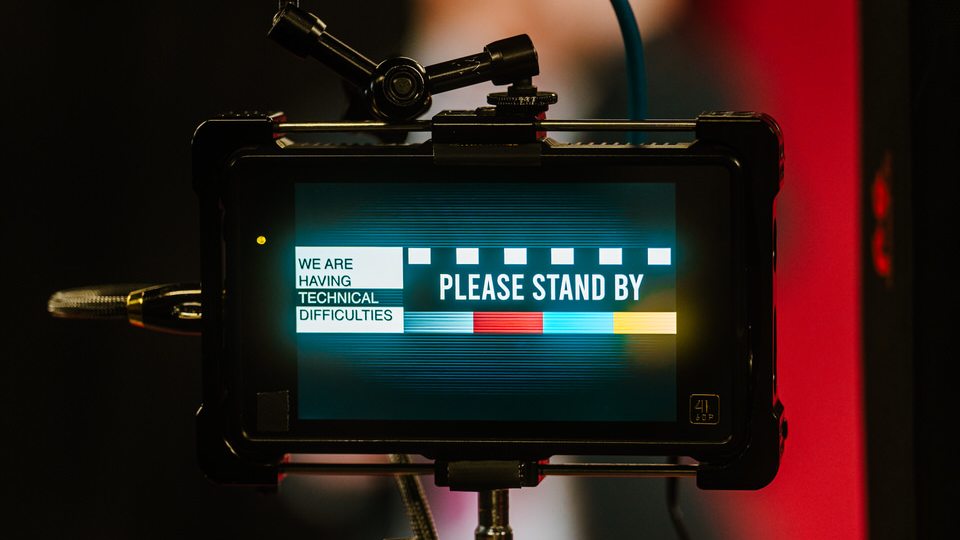 A camera monitor showing a Please Stand By screen